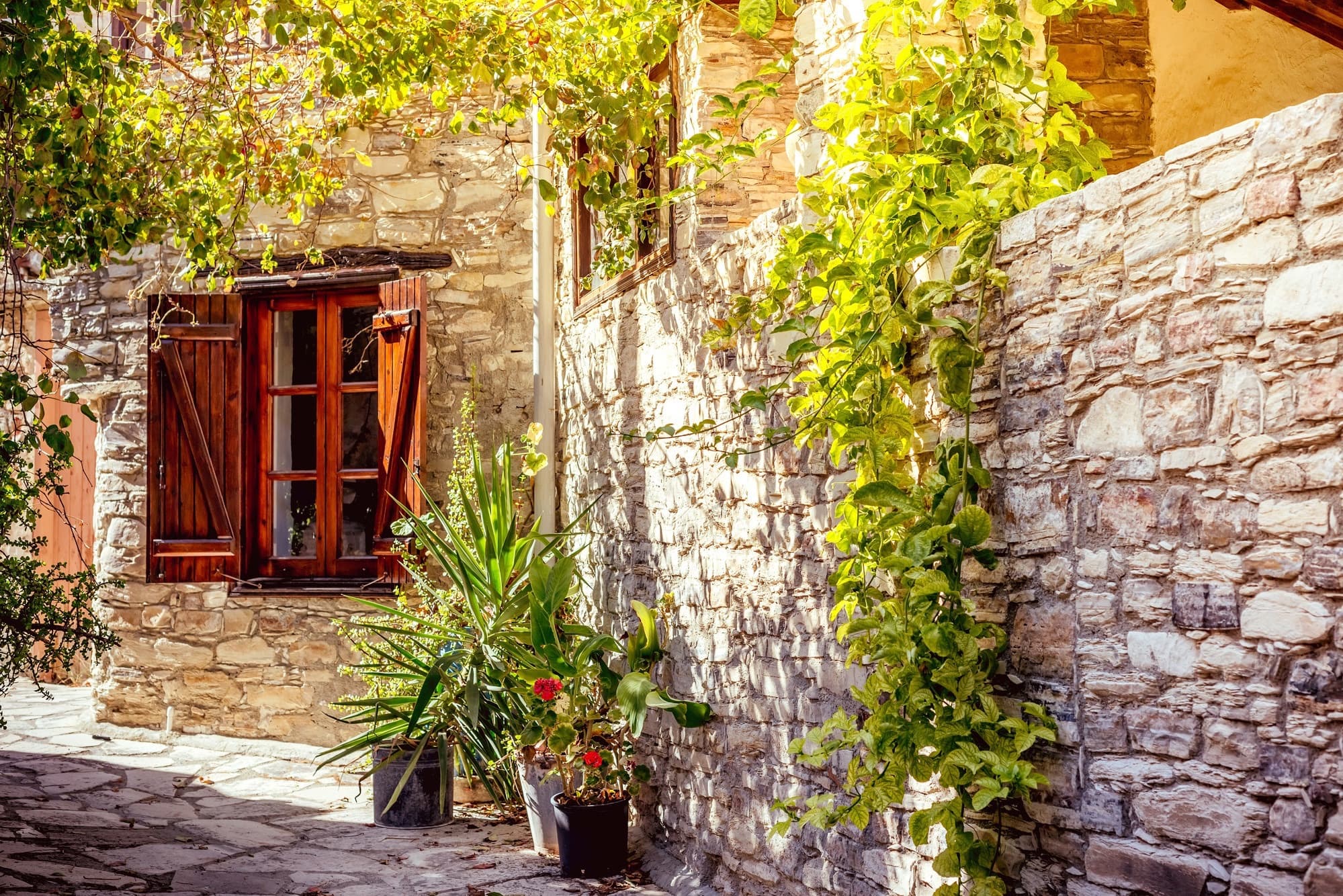 Smal steegje met stenen huizen en bloemen in het bergdorp Lefkara, Cyprus
